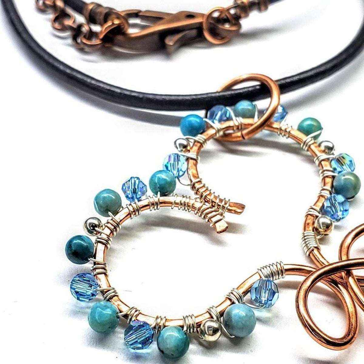 Copper wire infinity charm with turquoise heart and silver beads on adjustable brown leather necklace.