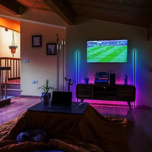 Corner floor lamp with RGB LEDs showing multi-color illumination against a white wall.