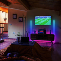 Black RGB LED corner floor lamp glowing with colorful lighting in a modern room corner.