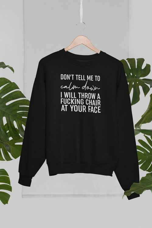 Grey sweatshirt hanging on wood hanger against a palm tree background