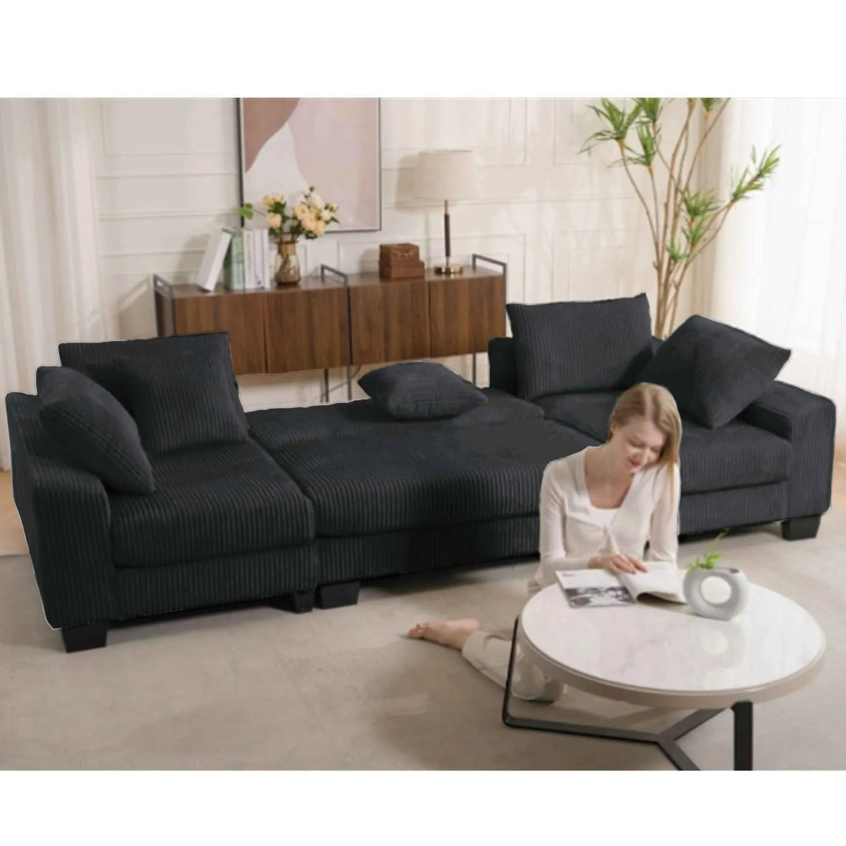 Black U-shaped sleeper sofa with corduroy upholstery and plush cushions in modern living room setting.