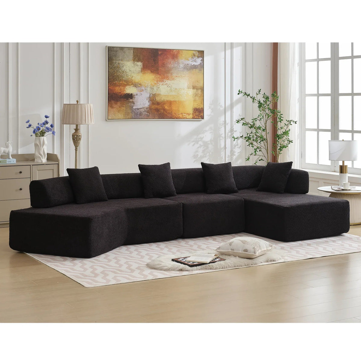 Side profile of spacious modern black L-shape sectional couch with plush seats.