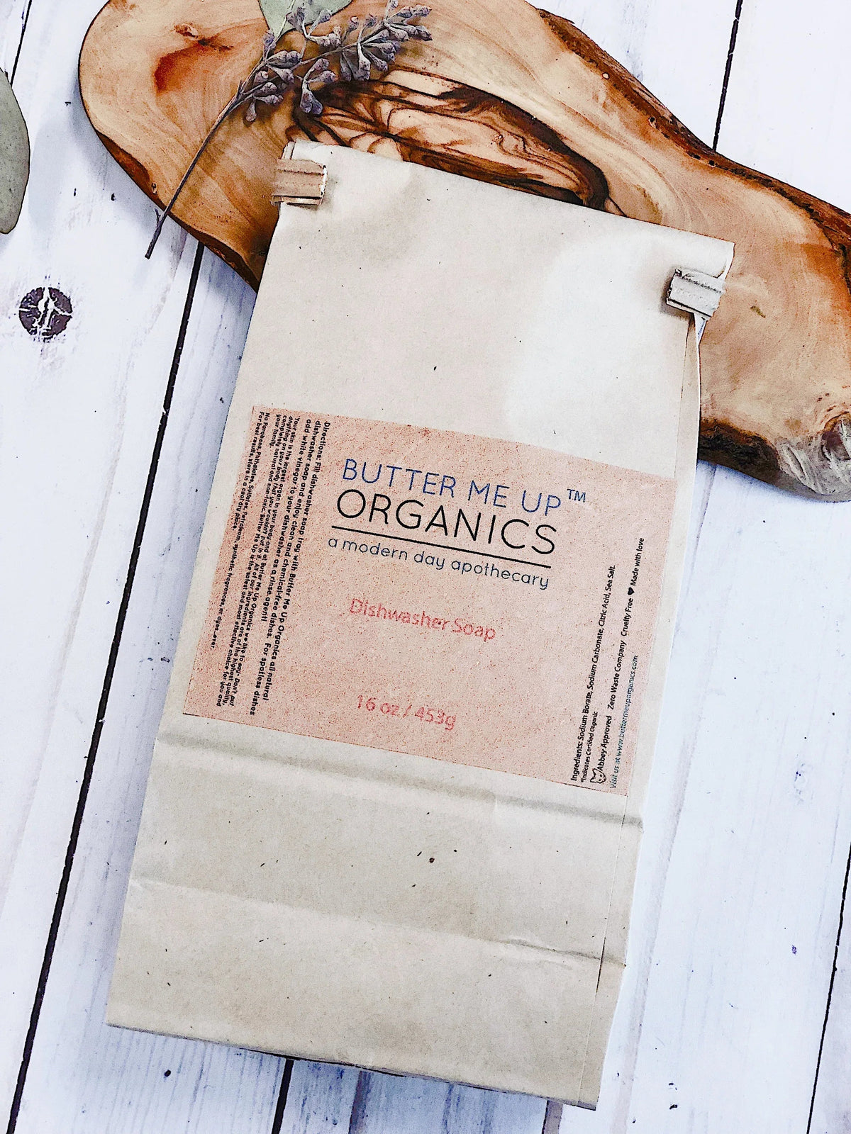 Measuring spoon filled with all natural dishwasher soap powder over wooden background