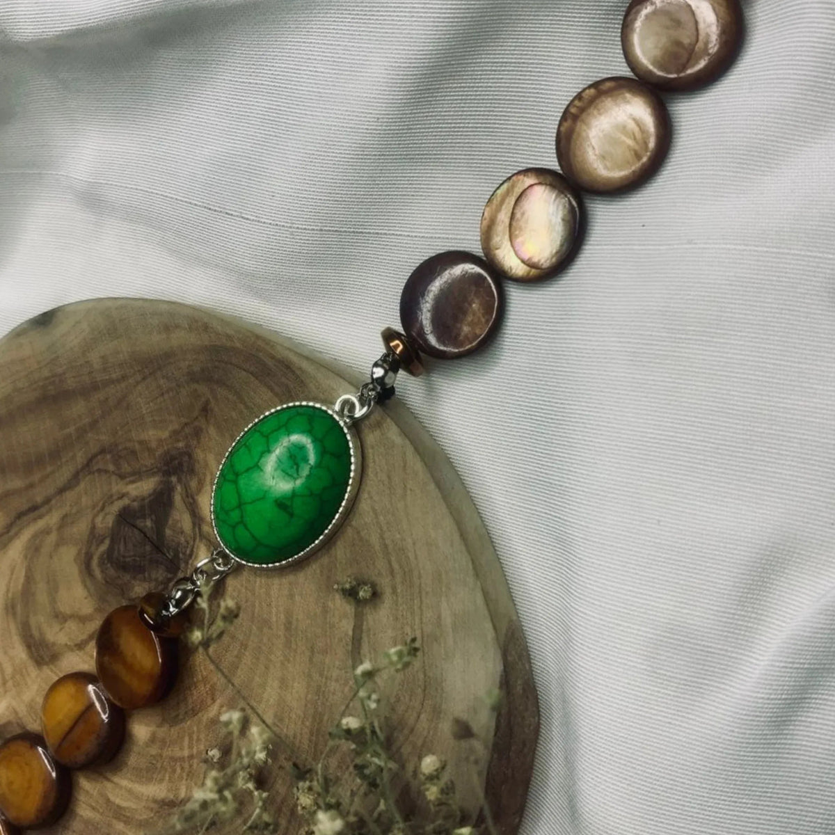 Stylish natural stone bracelet with distinctive green turquoise and brown beads displayed.