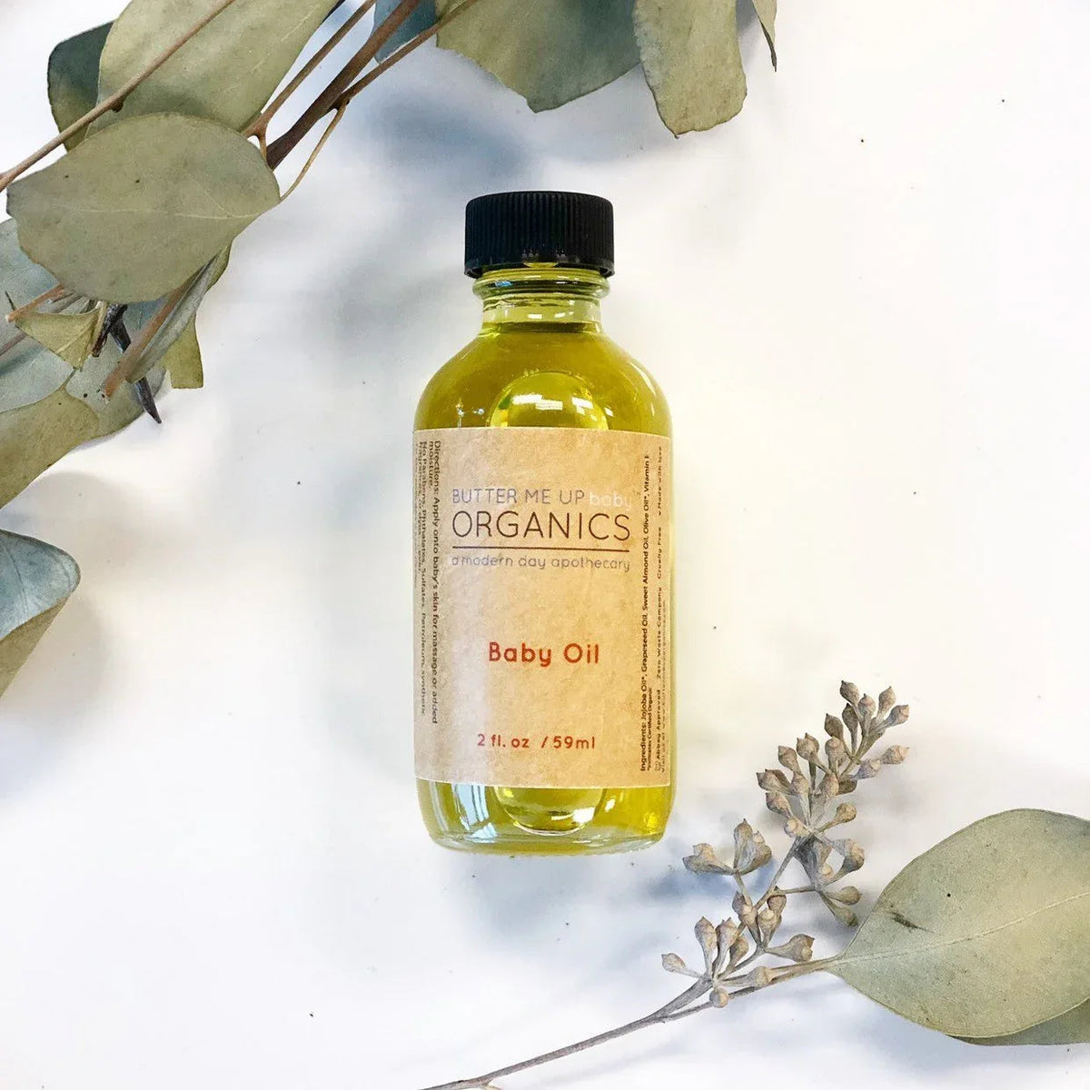 Organic Gentle Baby Oil in a 2 oz glass bottle with metal screw top on a white background