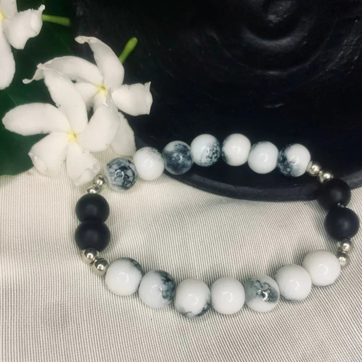 Close-up of Howlite and Black Onyx stretch bracelet with silver spacers showing natural bead textures.