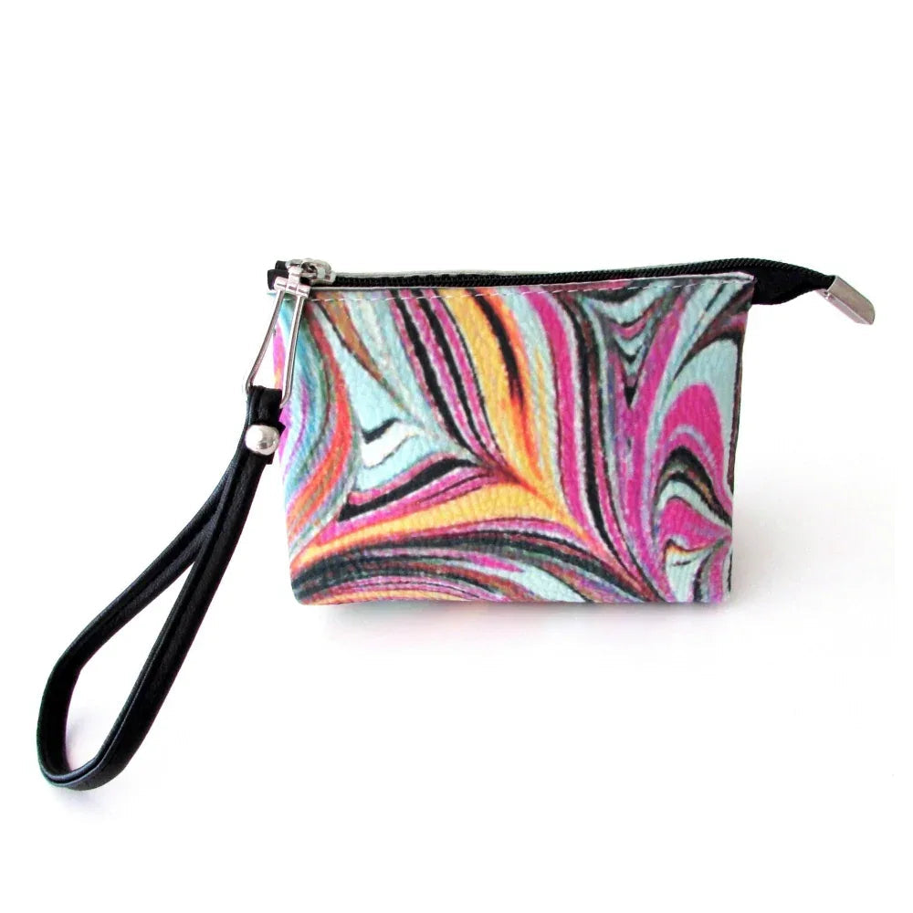 Close-up of red wristlet bag’s textured microfiber fabric showing artistic pomegranate pattern.