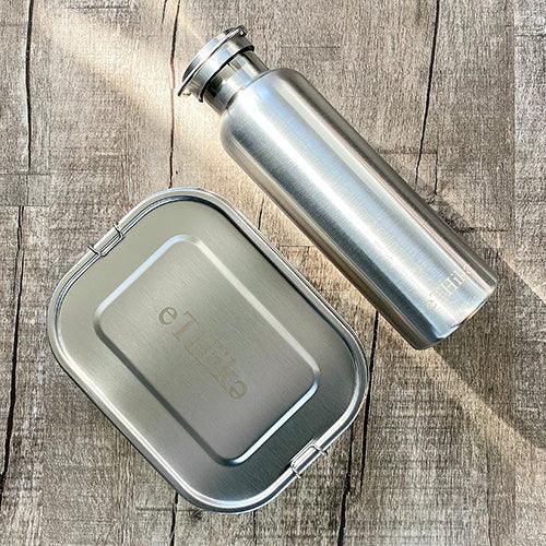 Stainless steel lunchbox with flexible divider showing compartments for different foods.