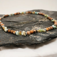 Multi-color natural agate stone necklace laid out to highlight varied bead shapes and colors.