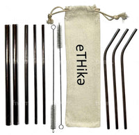 Stainless steel straws placed in a circular arrangement with a cleaning brush and cotton pouch on a flat surface.
