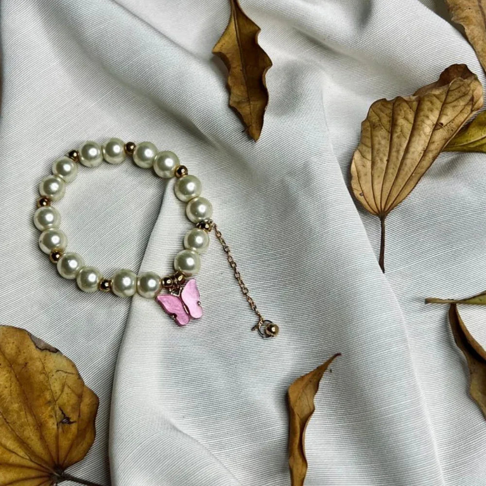 Side view of stretch faux pearl bracelet with purple butterfly detail for girls