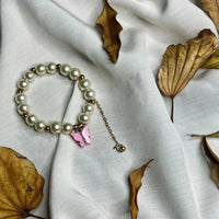 Side view of stretch faux pearl bracelet with purple butterfly detail for girls