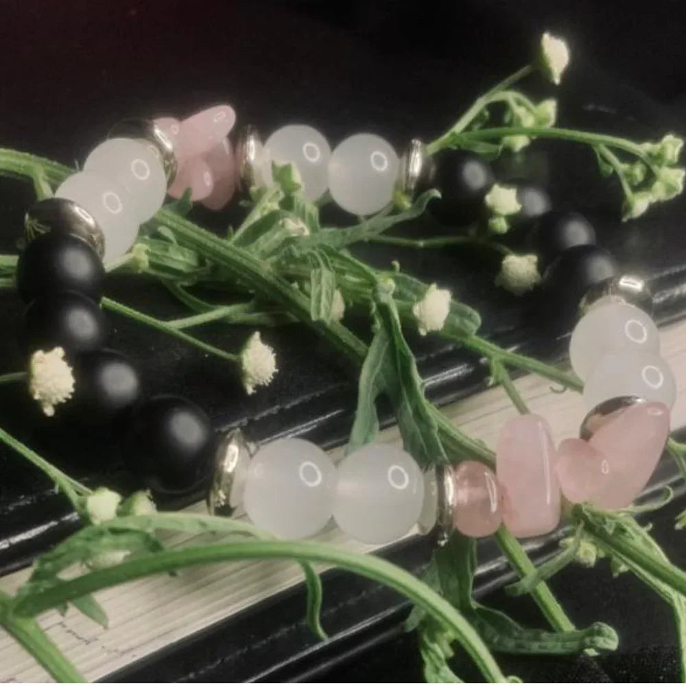 Natural stone bracelet displayed on wrist with polished black, white, pink beads and silver spacer details