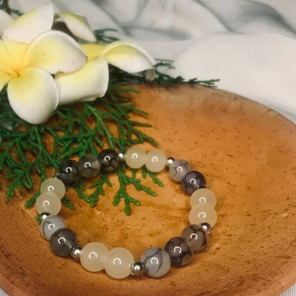 Artistic shot of agate gemstone bracelet highlighting the color variation in stones and silver spacers.