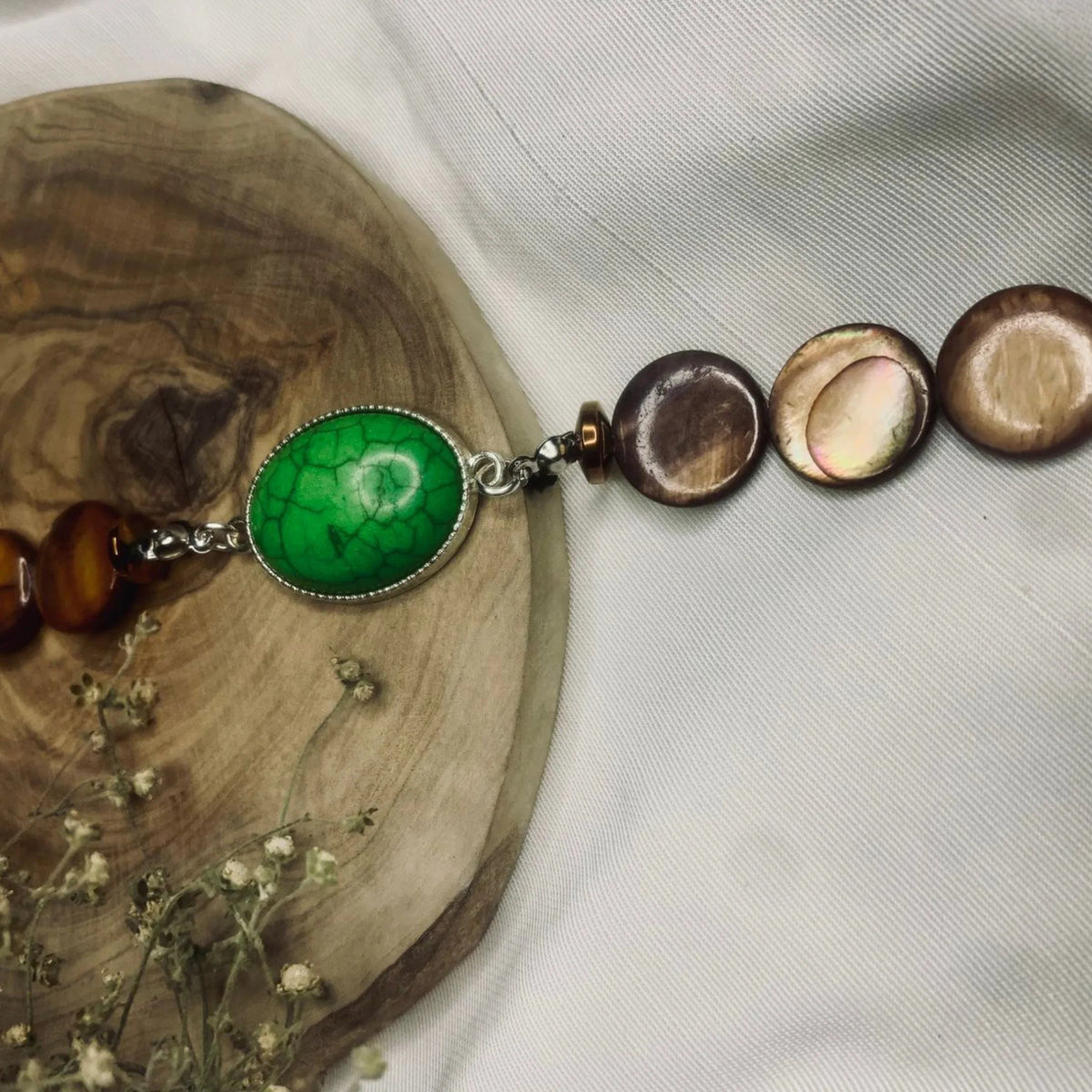 Top view of green turquoise and brown bead bracelet displayed on white background.
