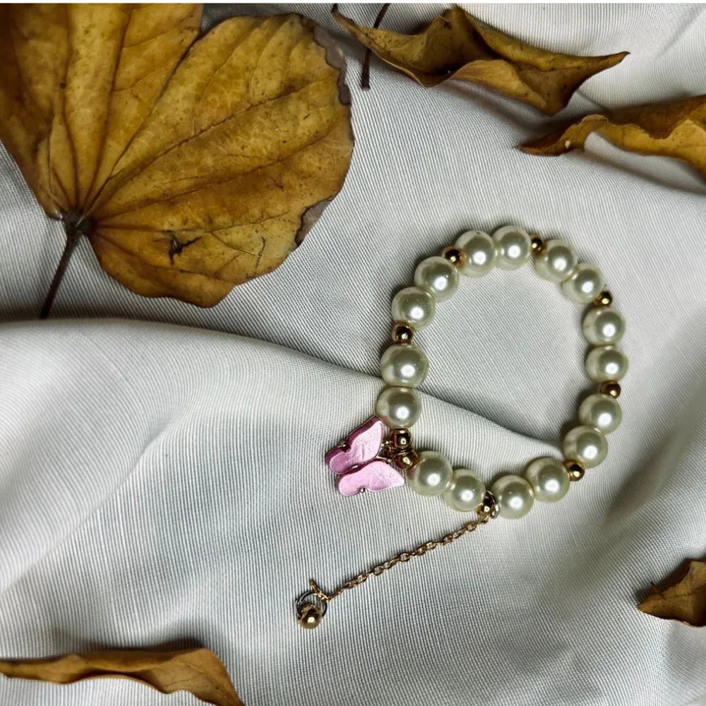 Bracelet composed of glossy faux pearls accented by a delicate purple butterfly charm