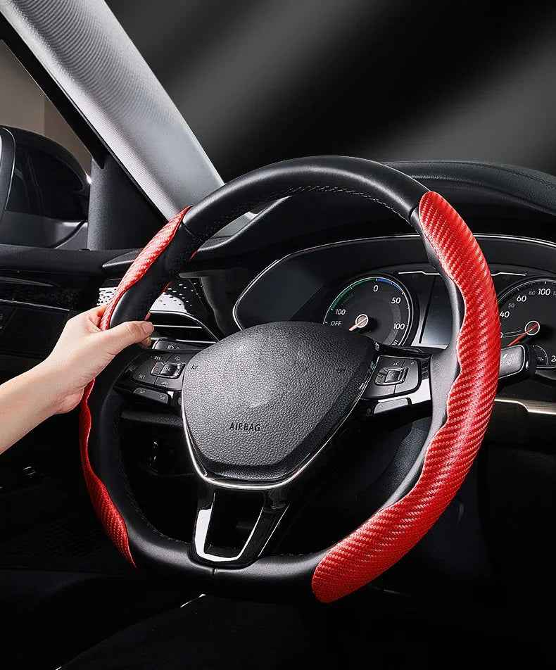 A pair of slim, black carbon fiber steering wheel covers fitted on a car steering wheel.