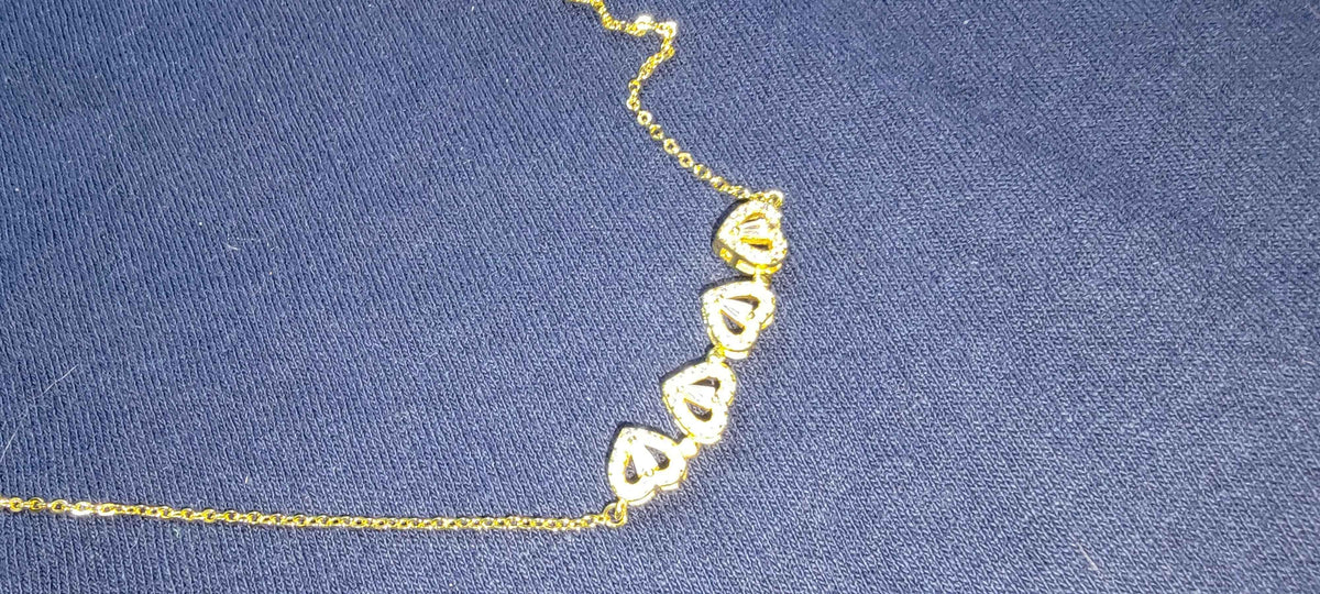 Four-leaf clover and heart shape necklace displayed on white, highlighting polished silver finish.
