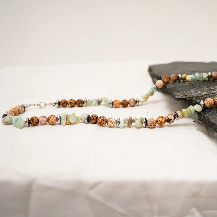 Close-up of multi-color natural agate stone necklace showing warm brown, cream, and green beads.
