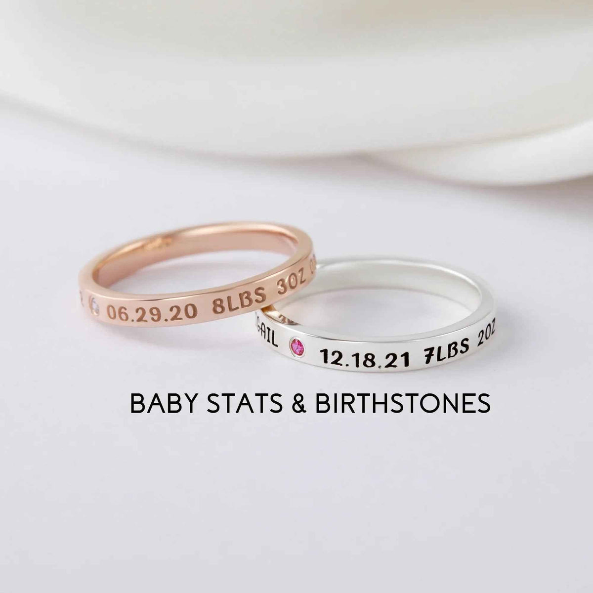Close-up of a personalized silver ring engraved with baby names, designed for new moms.