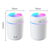 Compact air humidifier next to smartphone and car keys on car dashboard, showing travel use.