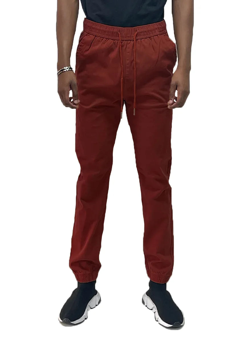 Close-up of jogger pants showing elastic ankle cuffs and fabric texture in neutral lighting.