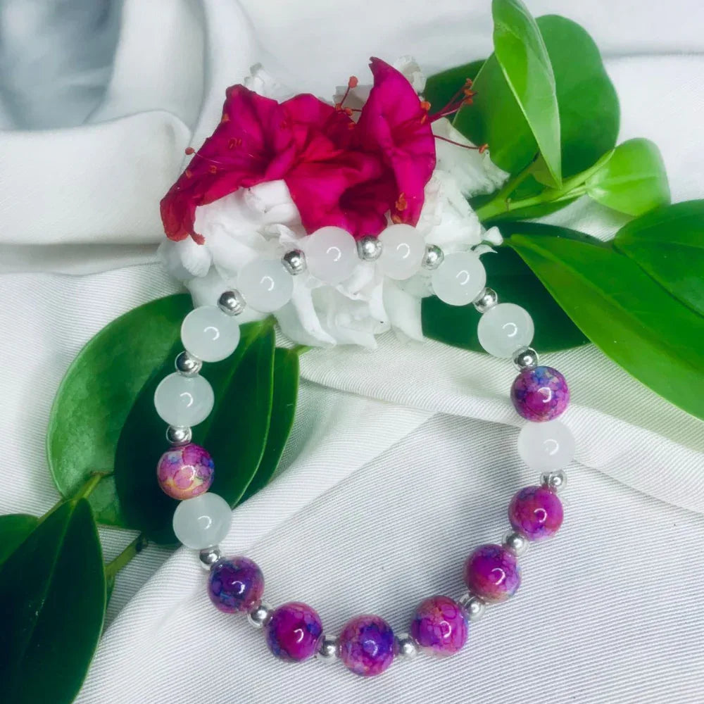 White and purple stone stretch bracelet wrapped around displaying bead textures and silver spacers.