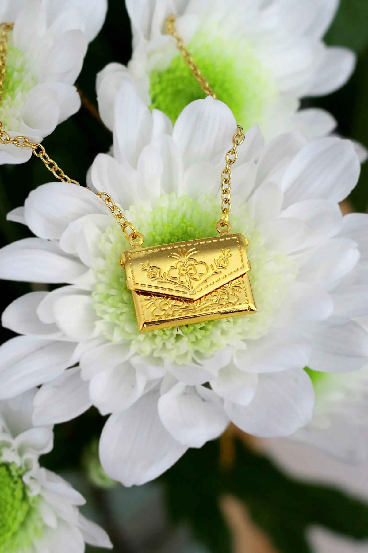 Gold-plated envelope locket necklace engraved with a daisy, shown on a delicate adjustable chain.