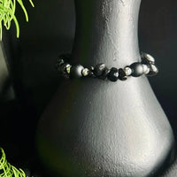 Detailed view of natural black stone chips forming a stretch cord bracelet.