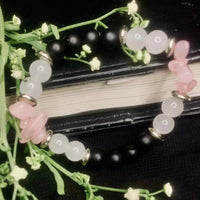 Close-up of handmade bracelet with black onyx, white jade, and rose quartz beads with silver spacers