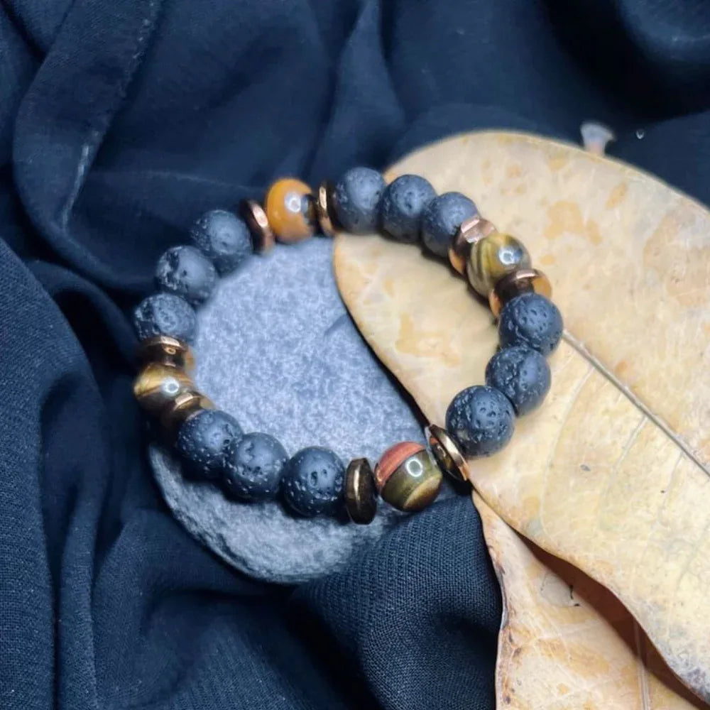Black Lava and golden Tiger Eye stone bracelet with copper-colored spacers displayed flat.
