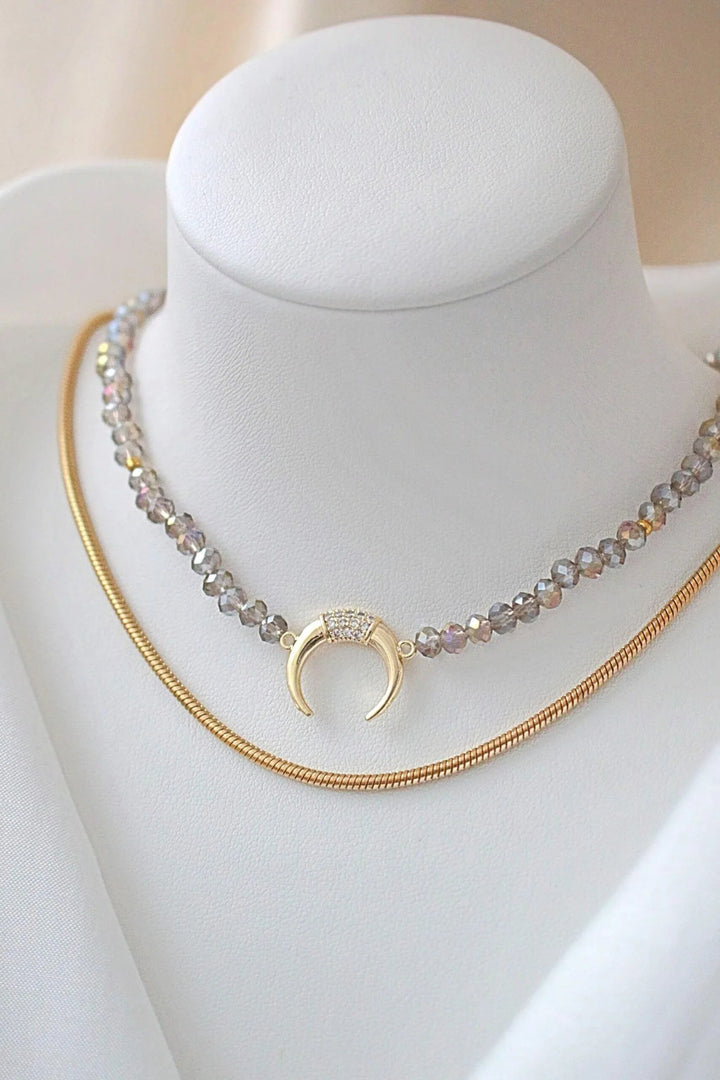 Close-up of light blue chrome Austrian crystal choker with sparkling surface and gold-plated charm pendant.
