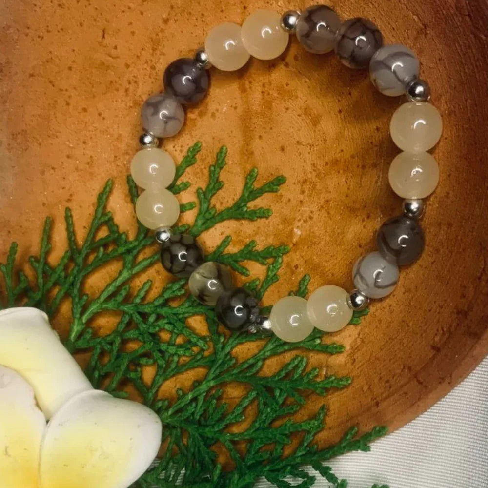 Elastic stretch bracelet featuring natural agate beads in gray and white tones with silver spacers.