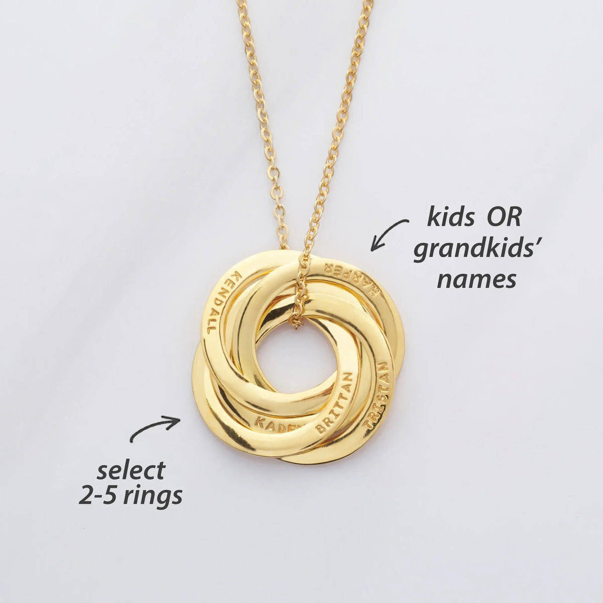 Silver interlocking rings necklace displayed on a white background, showing multiple polished circular pendants.