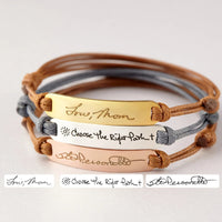 Close-up of a sterling silver bracelet engraved with personalized handwriting.