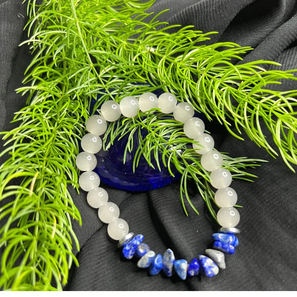 Bracelet featuring alternating white round beads and small blue stone chip beads arranged in circle.