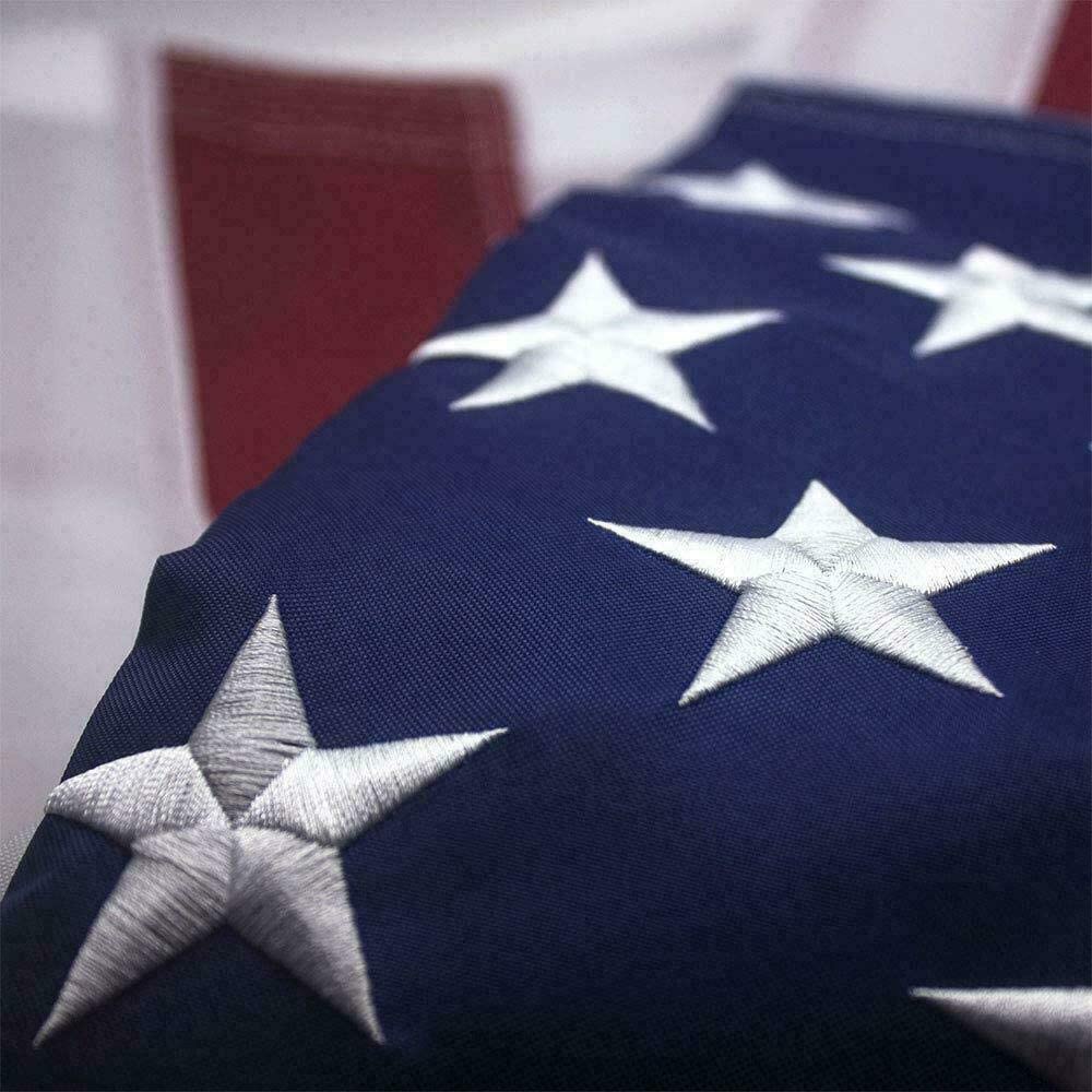 Top view of American flag showing embroidered stars with brass grommets on weather-resistant fabric.