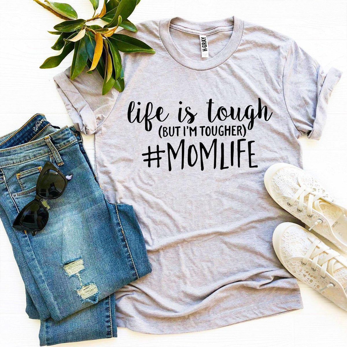 Front view of white #Momlife T-shirt laid flat showing full printed design