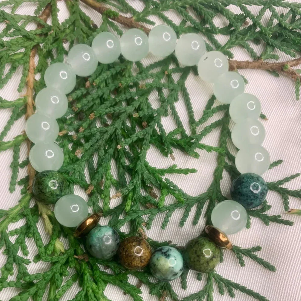 Top-down view of a green and white stone bracelet accented with copper spacers