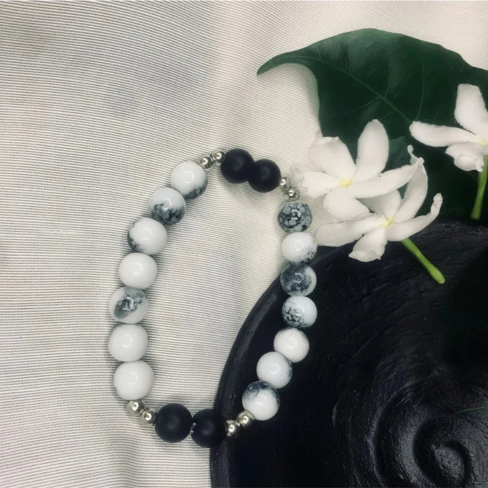 Howlite and Black Onyx beaded bracelet with silver spacers displayed on a neutral background.