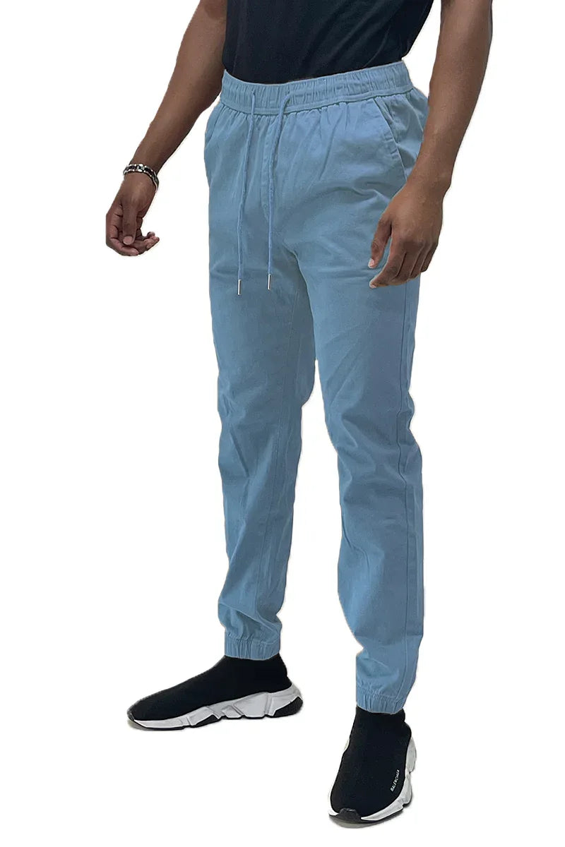 Front view of solid jogger pants with elastic waistband and pockets laid flat on a white surface.