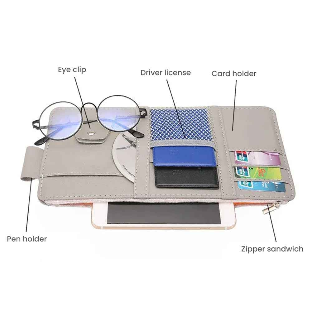 Black sun visor organizer open displaying compartments with cards, pen, and sunglasses inside car