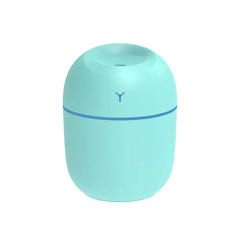 Close-up of white ultrasonic essential oil diffuser showing mist and illuminated LED glow.