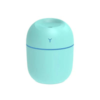 Close-up of white ultrasonic essential oil diffuser showing mist and illuminated LED glow.