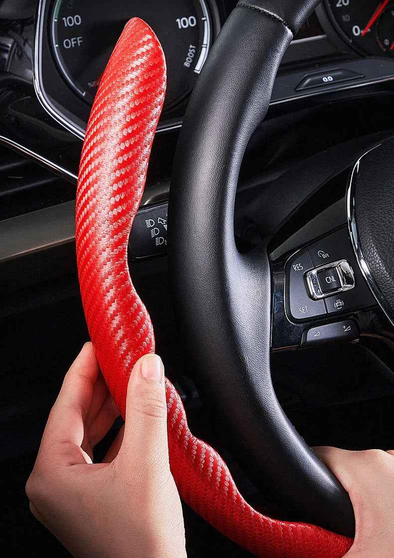 A pair of sleek black carbon fiber-pattern steering wheel covers fitted on a car steering wheel.