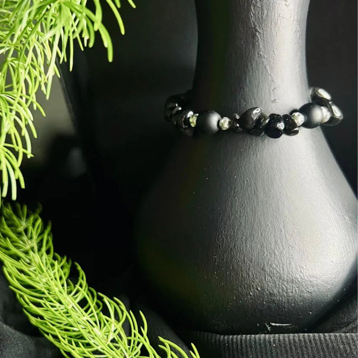 Close-up of black polished stone chip boho bracelet on a white background.