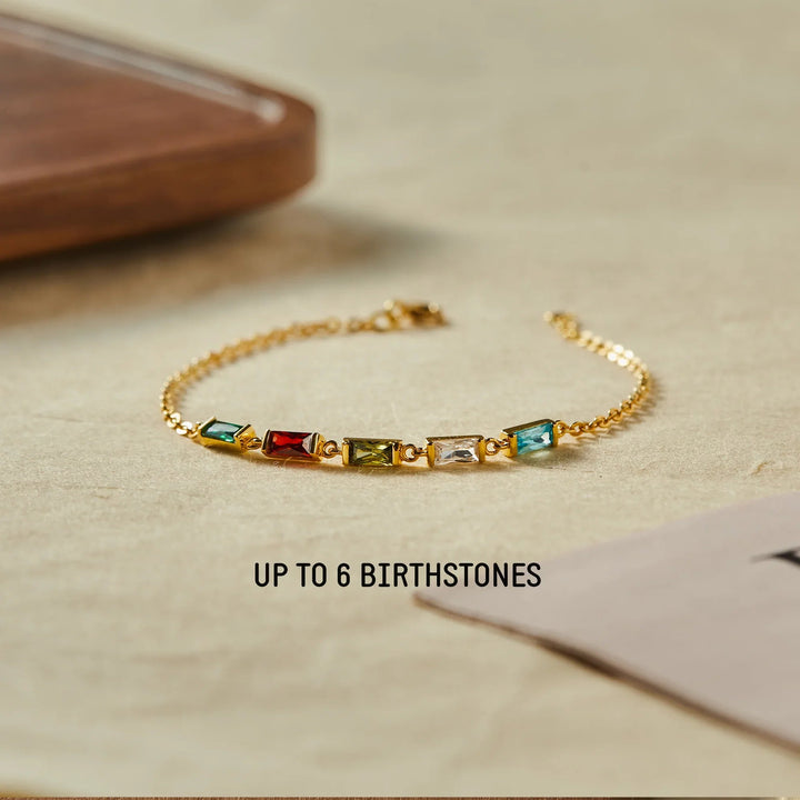 Close-up of a silver mom bracelet with six colorful birthstone charms on a white background.