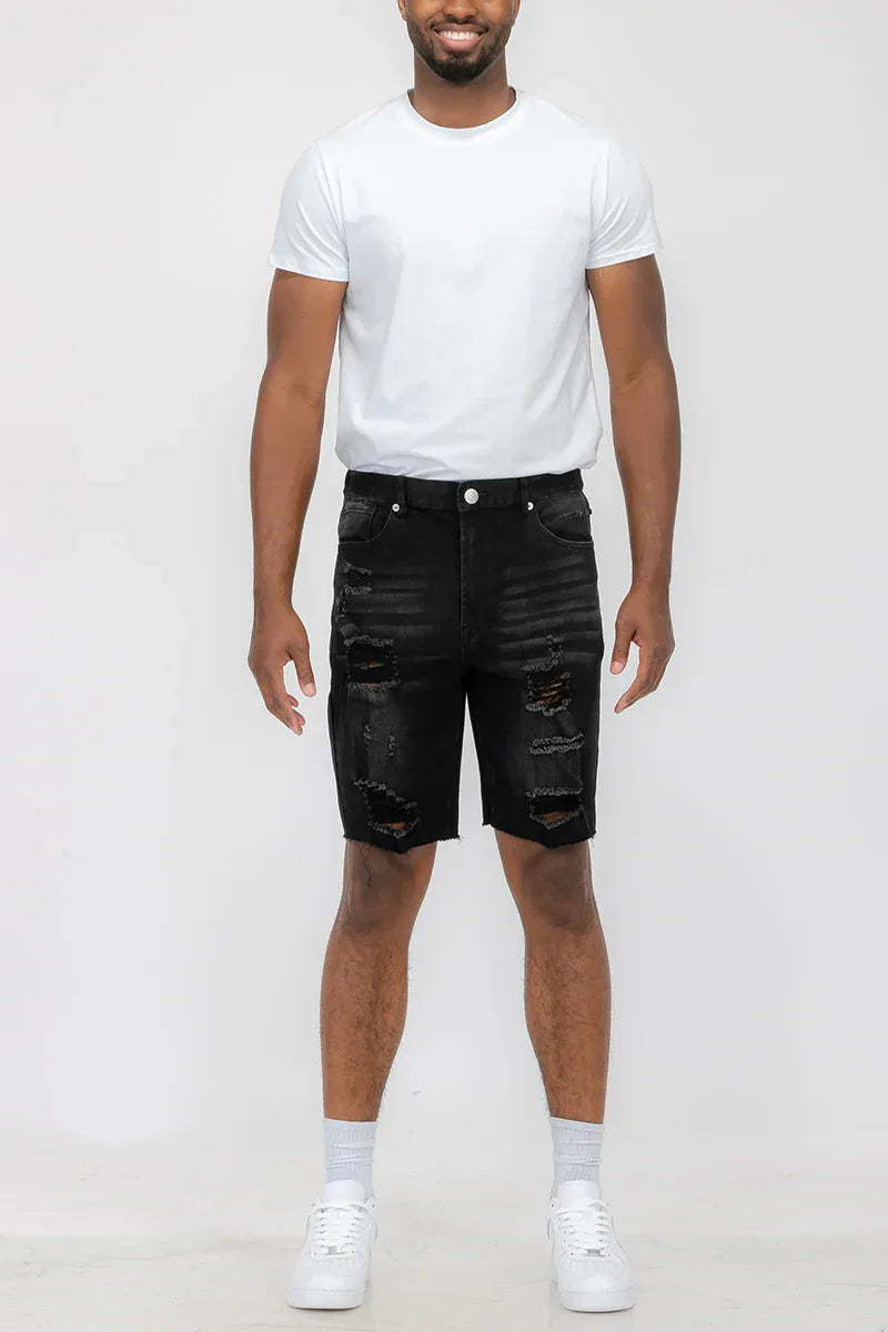 Close-up of the distressed fabric and button closure on men's denim shorts.