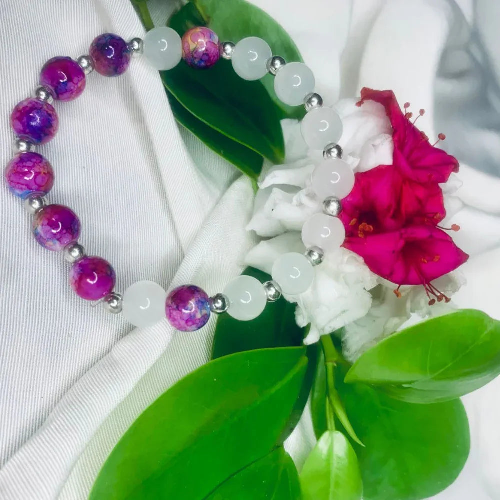 Detailed view of the polished white and purple stones separated by silver spacers on bracelet.