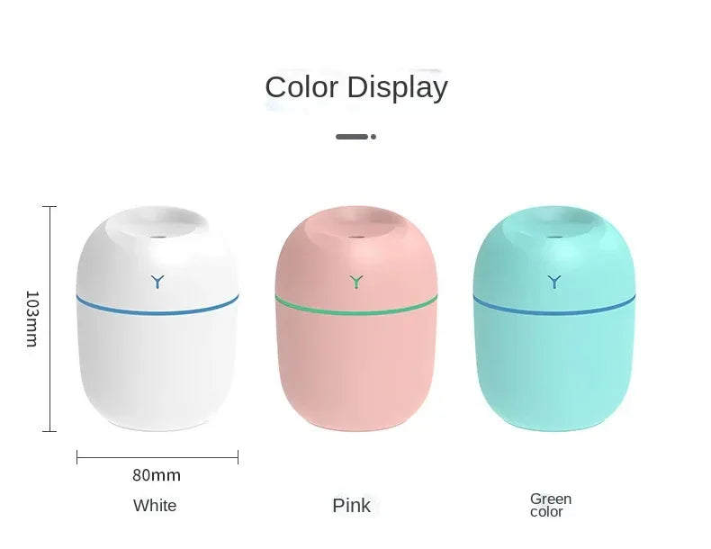 Teal ultrasonic humidifier emitting mist with LED light glowing in dark background.